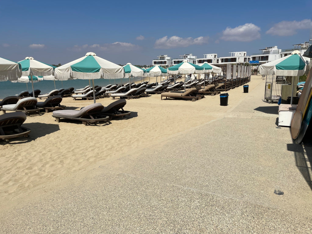 Peaceful sandy beach with sun loungers and turquoise parasols