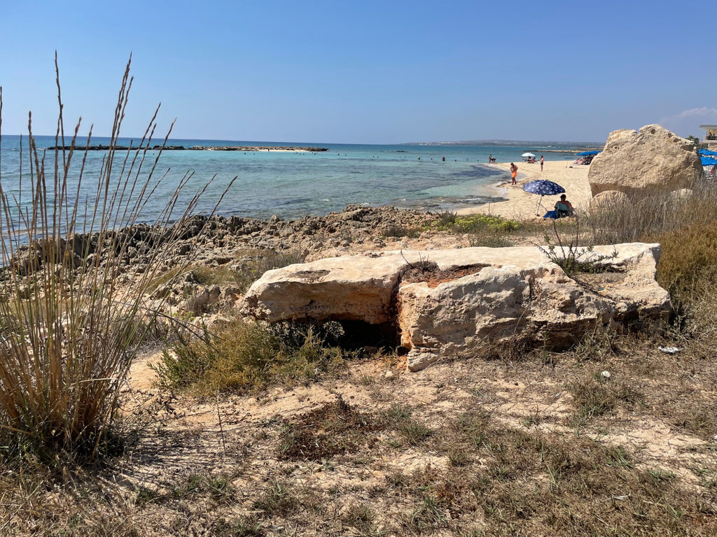 Peaceful turquoise coastal bay with sandy beach and rocky foreground