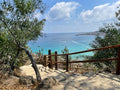 Scenic steps overlooking a calm turquoise bay framed by trees